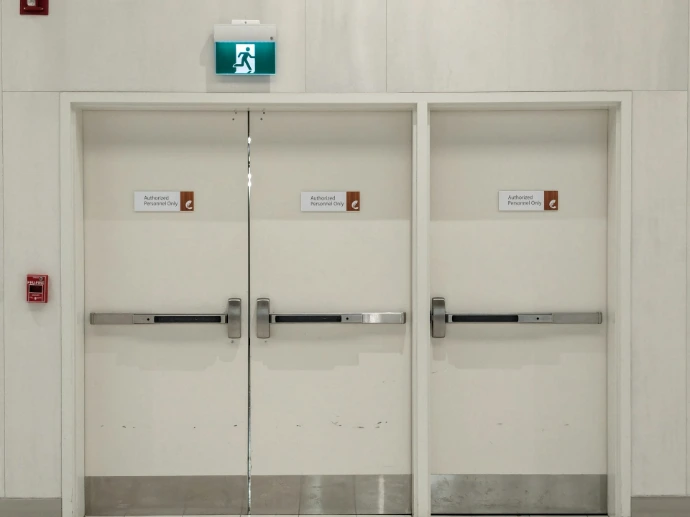 a white room with two doors and some signs on the doors